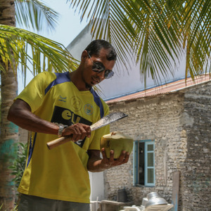 Preparing coconuts for drinking with a machete