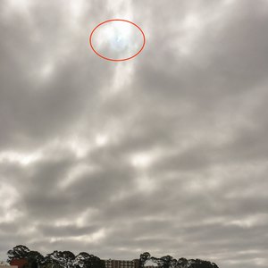 Eclipse peeking through the clouds